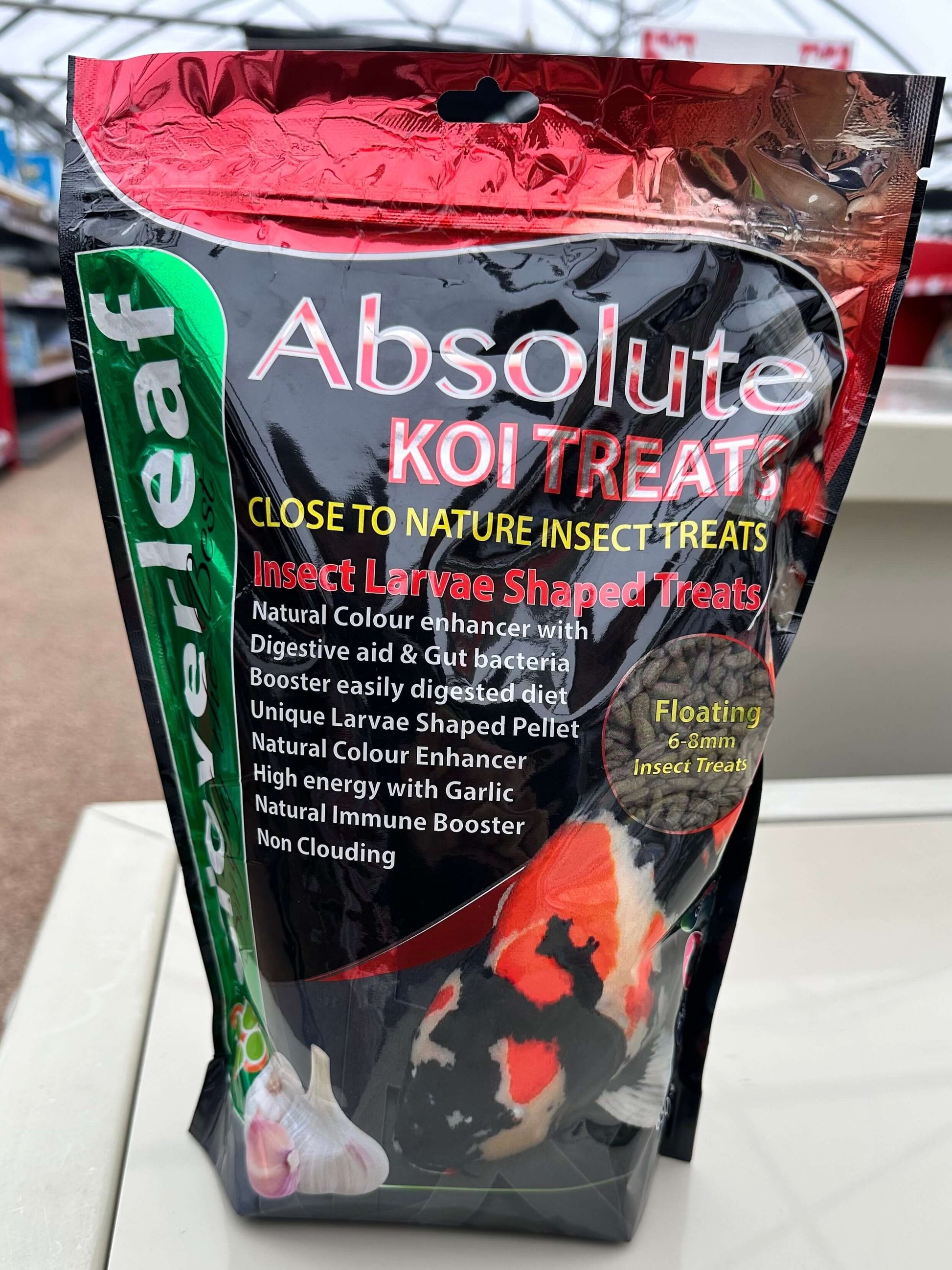 Cloverleaf Koi Treats Insect Larvae Garlic packaging showcasing high-protein floating pellets for koi and pond fish.